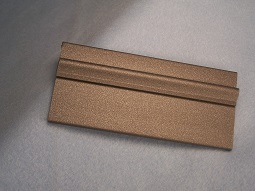 A custom extruded profile with a tan, speckled, pebble finish